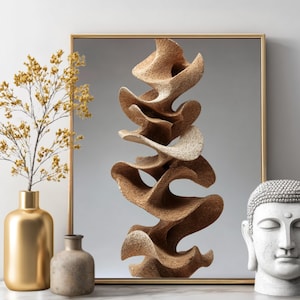 Puede incluir: Una escultura abstracta moderna con un diseño orgánico en capas en tonos beige y marrón. La obra de arte se exhibe en un espejo con marco dorado, junto con un jarrón dorado con ramas amarillas, un pequeño jarrón de piedra y una cabeza de Buda blanca.