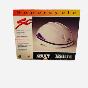 May include: A white Supercycle adult bicycle helmet in its original box. The helmet has a streamlined design with purple and blue accents. The box features the brand name, helmet features, and the text "ADULT".