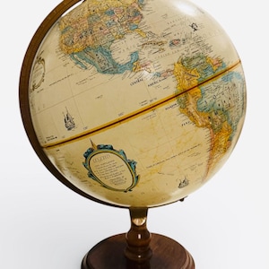 Może przedstawiać: Globus w stylu vintage z kremową kulą, prezentujący kontynenty i kraje w różnych kolorach. Globus jest zamontowany na ciemnej drewnianej podstawie z pasującym południkiem i podstawą. Widoczna jest ozdobna etykieta.