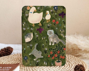 Puede incluir: Una funda verde para tableta con una ilustración caprichosa de patos, gatos y flores. Los patos llevan pajaritas azules y los gatos son grises y blancos. El fondo es un campo verde con varias flores y plantas.