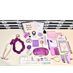 May include: A curated collection of nurse essentials in shades of purple and pink. Includes a stethoscope, scrunchie, notebooks, pens, eye mask, and other accessories. The text reads "Nurse Report Book" and "Vital Signs".
