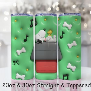 Peut inclure: Trois gobelets isothermes verts avec Snoopy et Woodstock sur la niche de Snoopy. Les gobelets sont décorés de notes de musique, d'os et de points jaunes. Le texte "20oz & 30oz Straight & Tapered" est imprimé en bas.