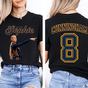 May include: A black short-sleeve t-shirt featuring a graphic of a basketball player pointing with the text "Spicy Sophie" on the front. The back of the shirt displays the name "CUNNINGHAM" in a collegiate font above the large jersey number 8.
