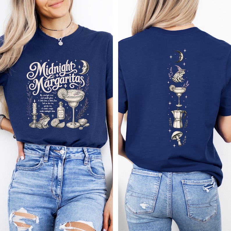 May include: A navy blue t-shirt featuring a front graphic with the text Midnight Margaritas, a margarita glass, a frog in a hat, a candle, and a bottle. The back graphic displays a vertical arrangement of a crescent moon, a frog, a margarita, a coffee pot, and a mushroom.
