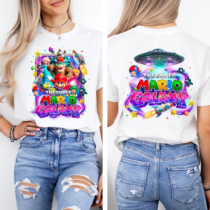 May include: White t-shirt featuring a colorful graphic from "The Super Mario Galaxy" video game. The front design includes Mario, characters, and text. The back design shows a spaceship and the game's logo.
