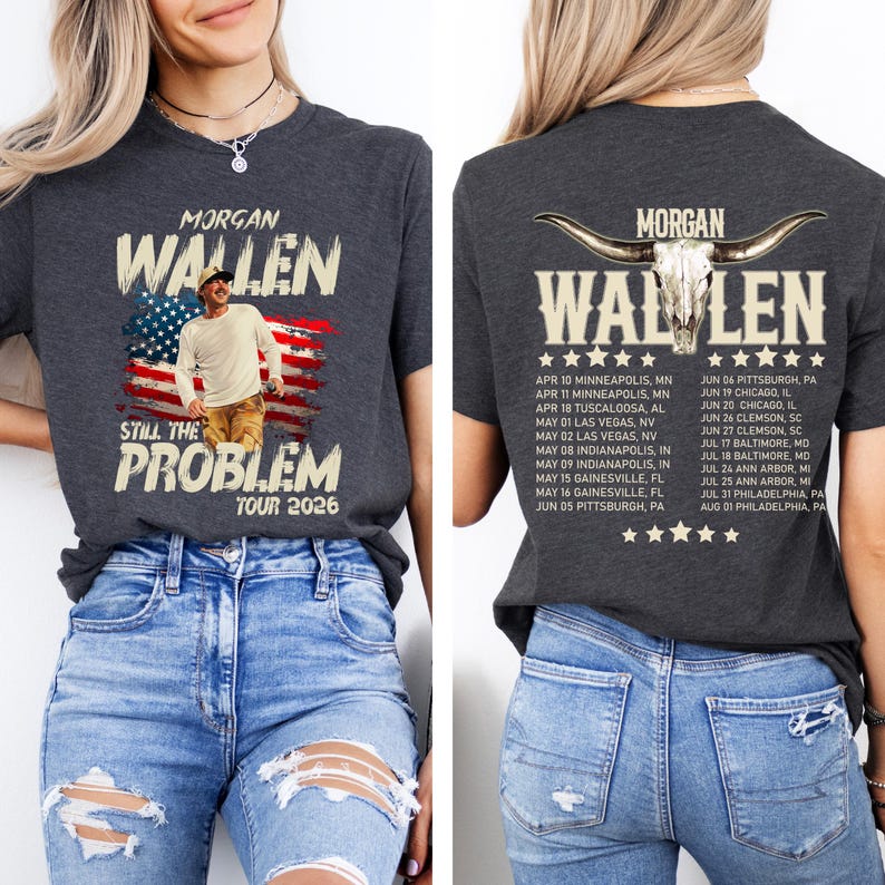 May include: Dark gray t-shirt featuring the text "MORGAN WALLEN" above an image of the American flag and a man. The shirt also includes the text "STILL THE PROBLEM TOUR 2026". The back of the shirt has a list of tour dates.