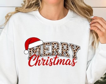 May include: White sweatshirt with the text "MERRY Christmas" in a festive design. The word "MERRY" has a leopard print pattern, and the word "Christmas" is in red script. The sweatshirt is part of a Christmas-themed pajama set.