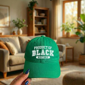 Pu&ograve; includere: Un cappellino da baseball verde con la scritta bianca "PRODUCT OF BLACK HISTORY". Il cappellino &egrave; realizzato in tessuto morbido e ha una visiera curva. Un cappello classico per l'uso quotidiano.