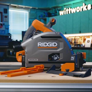 May include: A grey and orange Ridgid circular saw with a 9-1/2 inch blade. The saw is labelled "Brushless" and has a dust port. The saw is sitting on a wooden surface with a black and orange guide rail.