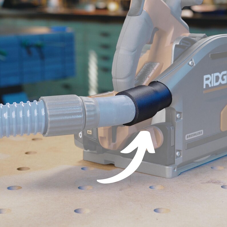 May include: A gray and black power tool with a dust collection hose attached. The hose is connected to the tool with a black adapter. The tool has the word "RIDGID" printed on it.