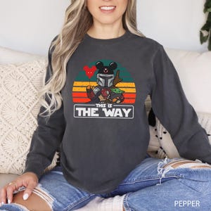 May include: A set of three ceramic mugs with a speckled, matte finish. The mugs are in shades of cream, light gray, and dark gray. Each mug has a simple, minimalist design and a rounded handle.