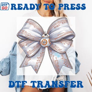Puede incluir: Una transferencia DTF (Directo a Pel&iacute;cula) con un dise&ntilde;o de lazo grande y detallado. El lazo es principalmente plateado con detalles de circuitos en cobre. Un droide BB-8 est&aacute; en el centro. Las palabras "READY TO PRESS" y "DTF TRANSFER" son azules.