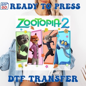 May include: A DTF (Direct to Film) transfer featuring characters from Zootopia 2. The design includes images of a sloth, fox, rabbit, and snake, with the title "Zootopia 2" in green and blue. The words "READY TO PRESS" and "DTF TRANSFER" are also displayed.