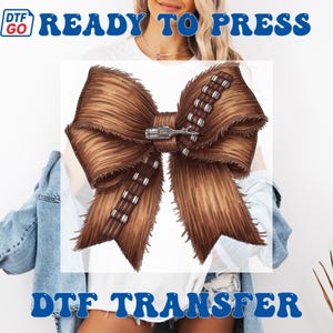 Puede incluir: Un dise&ntilde;o de lazo marr&oacute;n con textura peluda, que recuerda a la piel de un personaje de una pel&iacute;cula de ciencia ficci&oacute;n. El lazo presenta un detalle plateado y marr&oacute;n en forma de cintur&oacute;n en el centro. El texto "READY TO PRESS" y "DTF TRANSFER" est&aacute; en azul.