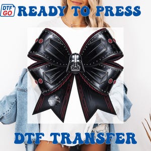 Puede incluir: Una transferencia DTF en forma de lazo negro con el casco de Darth Vader en el centro. El lazo tiene una apariencia met&aacute;lica con detalles rojos y remaches. La Estrella de la Muerte tambi&eacute;n es visible. Las palabras "READY TO PRESS" y "DTF TRANSFER" son azules.