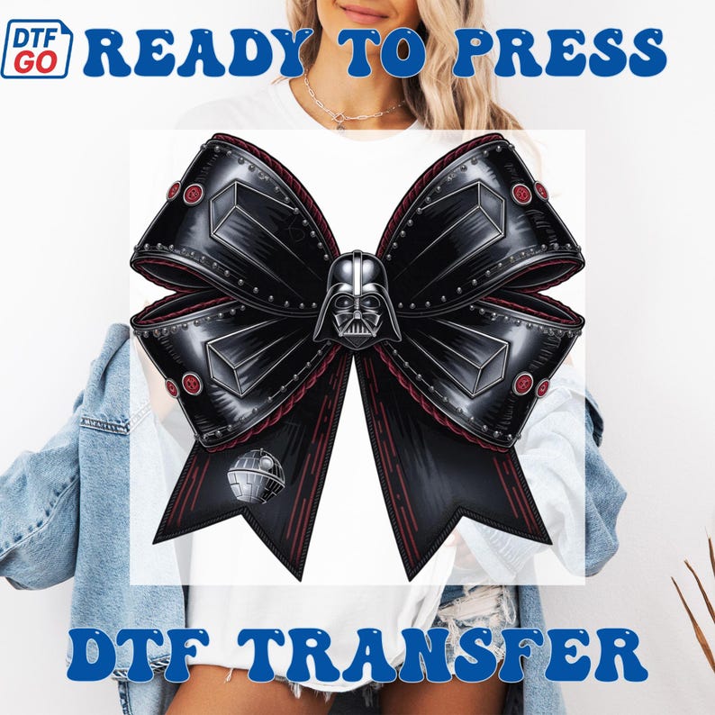Puede incluir: Una transferencia DTF en forma de lazo negro con el casco de Darth Vader en el centro. El lazo tiene una apariencia met&aacute;lica con detalles rojos y remaches. La Estrella de la Muerte tambi&eacute;n es visible. Las palabras "READY TO PRESS" y "DTF TRANSFER" son azules.