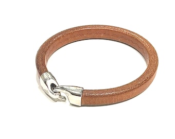 May include: A brown leather bracelet with a silver clasp.