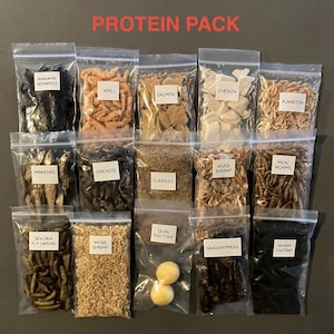 May include: A collection of clear plastic bags filled with various protein sources, including wakame seaweed, krill, salmon, chicken, and plankton. The bags are labeled with white text. The words "PROTEIN PACK" are displayed in red at the top.