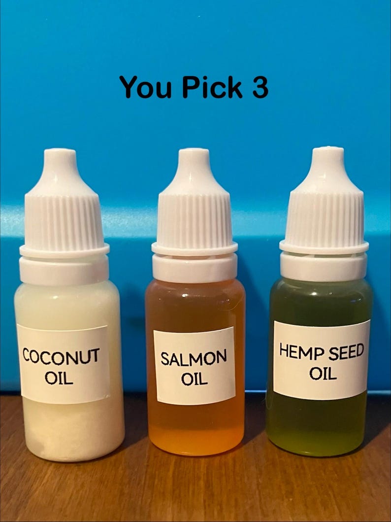 May include: Three small bottles with white caps and labels. The bottles contain coconut oil, salmon oil, and hemp seed oil. The text "You Pick 3" is above the bottles.