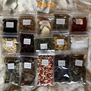 May include: A collection of clear plastic bags filled with various dried fruits, vegetables, and herbs. The bags are labeled with names like "Apples," "Blue Berries," and "Spinach." The text "Fruit & Veggie Pack" is at the top.
