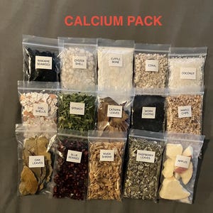 May include: A collection of small, clear plastic bags filled with various natural ingredients, including seaweed, oyster shell, and spinach. The bags are labeled with the contents, and the text "CALCIUM PACK" is displayed at the top. The contents are for aquarium use.