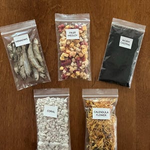 May include: Five clear plastic bags filled with various items, including dried minnows, a fruit medley, worm castings, coral, and calendula flowers. The text "You can pick 5" is written in red at the top.