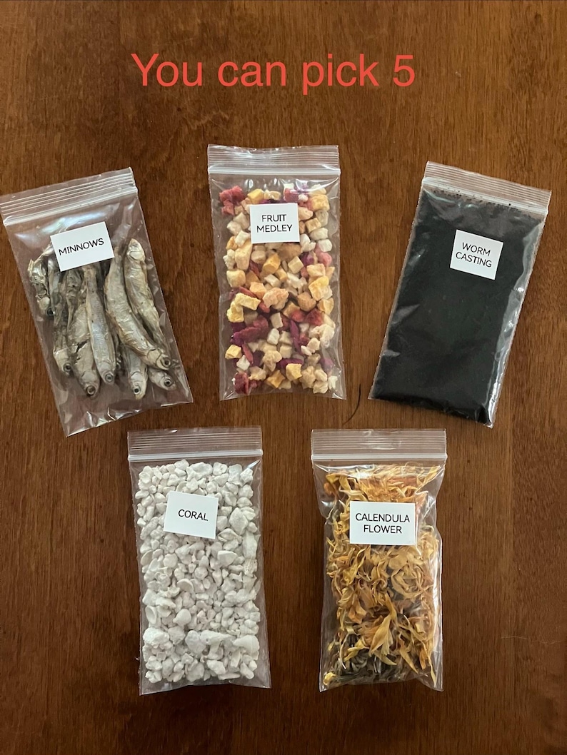 May include: Five clear plastic bags filled with various items, including dried minnows, a fruit medley, worm castings, coral, and calendula flowers. The text "You can pick 5" is written in red at the top.