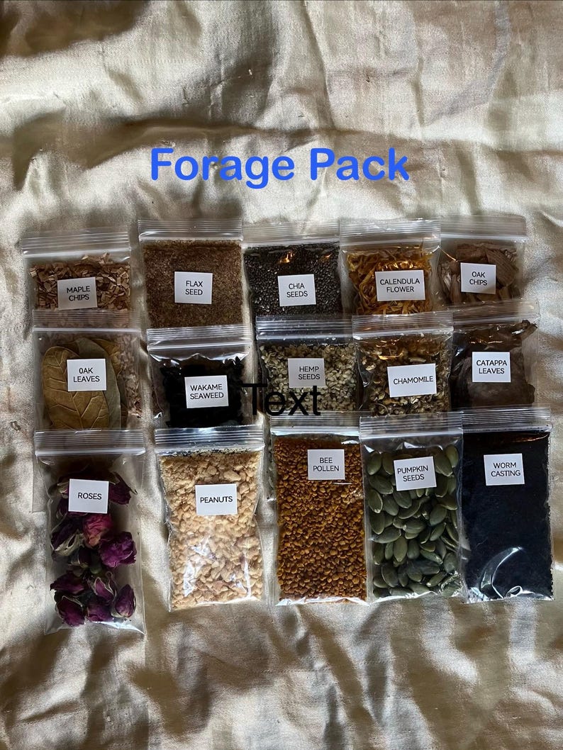 May include: A collection of small, clear plastic bags filled with various foraged items. The bags contain maple chips, flax seed, chia seeds, calendula flower, oak chips, oak leaves, wakame seaweed, hemp seeds, chamomile, catappa leaves, roses, peanuts, bee pollen, pumpkin seeds, and worm casting. The text "Forage Pack" is visible.