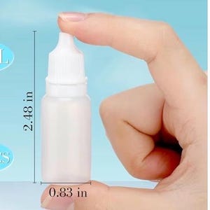 May include: A white plastic dropper bottle, 2.48 inches tall and 0.83 inches wide, is held between fingers against a light blue background. The bottle has a white cap and a clear body, with the words "PRODUCT SIZE" at the top.