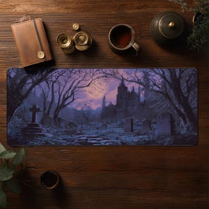 May include: A rectangular mousepad featuring a gothic graveyard scene with a full moon, a castle, and bare trees. The color palette includes shades of purple, gray, and black. A leather notebook, a cup of tea, and other items are on a wooden surface.