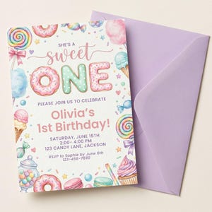 May include: A rectangular birthday invitation card with a light purple envelope. The card features watercolor illustrations of donuts, lollipops, ice cream, and candy with the text: SHE'S A sweet ONE, PLEASE JOIN US TO CELEBRATE, Olivia's 1st Birthday!