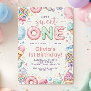May include: A rectangular birthday invitation card featuring watercolor illustrations of donuts, lollipops, ice cream, and candy. The text reads: She's a sweet ONE, Please join us to celebrate, Olivia's 1st Birthday, Saturday, June 15th, 2:00-4:00 PM, 123 Candy Lane, Jackson, RSVP to Sophie by June 6th 123-456-7890.