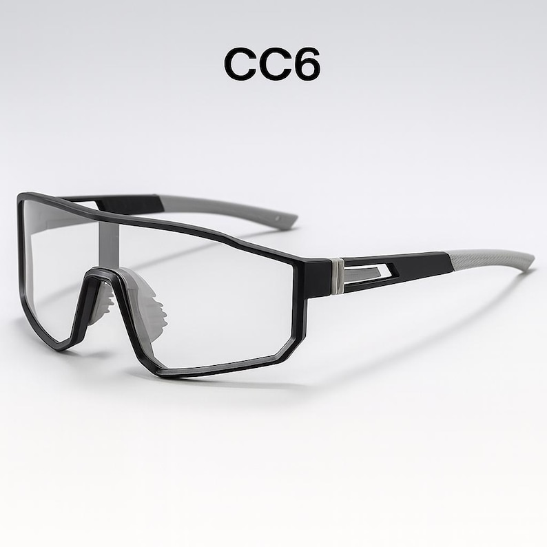 May include: Black and gray sports glasses with clear lenses. The glasses have a rectangular frame with a modern design. The text "CC6" is printed in black at the top of the image.