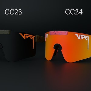 Puede incluir: Dos pares de gafas de sol Viper se muestran sobre un fondo oscuro. Un par tiene lentes negras con detalles naranjas, el otro tiene lentes naranjas y monturas rosas. Los textos "CC23" y "CC24" est&aacute;n encima de las gafas.