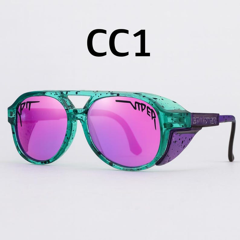Puede incluir: Gafas de sol verdes y moradas con lentes rosas. Las gafas tienen un dise&ntilde;o &uacute;nico con puente y protectores laterales. El texto "CC1" est&aacute; impreso en la parte superior. Las lentes son espejadas y las monturas son de color verde transl&uacute;cido.