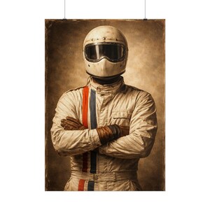 Op de afbeelding: Vintage posterprint van een autocoureur in een crèmekleurig racepak en helm. Het pak heeft rode en blauwe strepen. De coureur draagt bruine leren handschoenen en heeft de armen gekruist. De achtergrond is sepia.