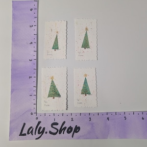 May include: Four small, rectangular Christmas tree stamps with a green tree design, gold star, and the words "To" and "From". The stamps are on a white background with a purple ruler and the text "Laly.Shop".