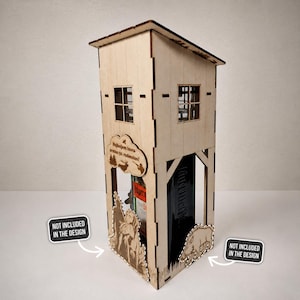 May include: A wooden liquor bottle holder shaped like a small cabin. The holder has two small windows and a roof. The front features a cutout with text and a bottle of Jägermeister. The sides have etched forest scenes.