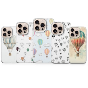 以下が含まれることがあります： カラフルな熱気球のデザインが施された5つの携帯電話ケース。ケースは、水彩画やスケッチの気球など、さまざまなパターンを特徴とし、白と水色の背景に設定されています。ケースはスマートフォンに合うように設計されています。