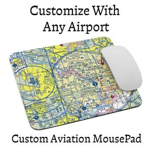 Peut inclure: Un tapis de souris rectangulaire présentant une carte aéronautique détaillée de la région de Washington D.C. avec des zones de couleurs jaune, bleue et blanche. Une souris d'ordinateur blanche repose sur le côté droit. Texte : Customize With Any Airport.