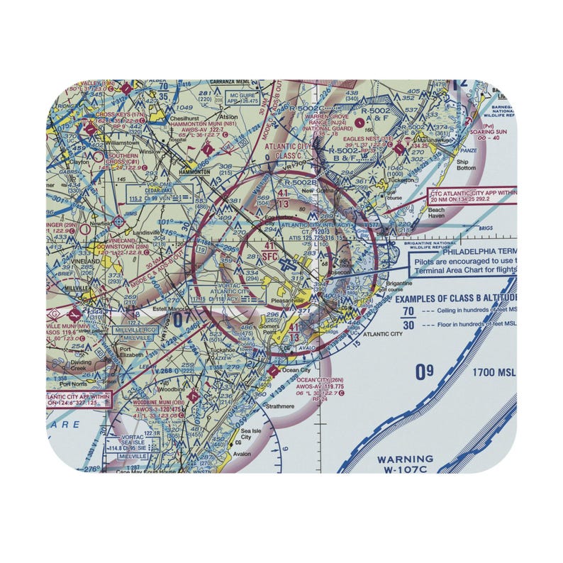 Puede incluir: Una alfombrilla de rat&oacute;n rectangular con una carta aeron&aacute;utica detallada de la regi&oacute;n de Atlantic City. El mapa muestra varias rutas de vuelo, &aacute;reas restringidas y datos de navegaci&oacute;n con etiquetas de texto que incluyen Atlantic City y Warning W-107C.