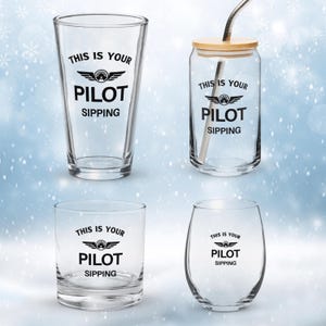 Puede incluir: Cuatro vasos transparentes con el texto "THIS IS YOUR PILOT SIPPING" en negro. Los vasos incluyen un vaso de pinta, un vaso en forma de lata con tapa de bambú y pajita de metal, un vaso de whisky y una copa de vino sin pie.