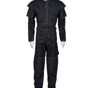 May include: Black jumpsuit with white stitching details. The outfit features a round neck, long sleeves, and padded shoulder accents. The pants have reinforced knee panels and a cargo pocket. The jumpsuit is displayed on a mannequin.