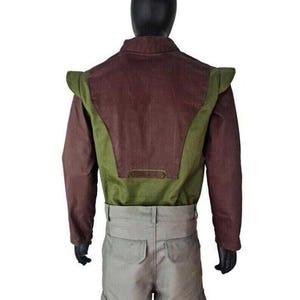 May include: A long-sleeved jacket featuring a dark brown back panel and olive green side panels with structured shoulder flaps, paired with light gray cargo pants that have two back pockets and side cargo pockets on a mannequin.