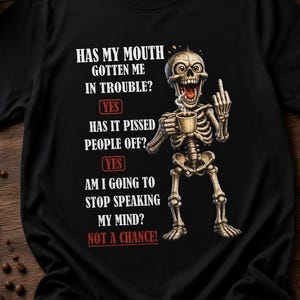 Może przedstawiać: Czarny t-shirt z grafiką szkieletu trzymającego kubek kawy i pokazującego środkowy palec. Tekst brzmi: Has my mouth gotten me in trouble? Yes. Has it pissed people off? Yes. Am I going to stop speaking my mind? Not a chance!