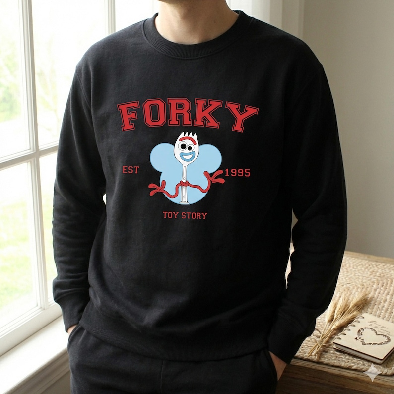 K&ouml;nnte beinhalten: Eine wei&szlig;e Keramiktasse mit schwarzem Henkel und dem Text "But First, Coffee" in fetter, schwarzer Schrift. Die Tasse steht auf einer Holzoberfl&auml;che. Die Tasse ist etwa 10 cm hoch.