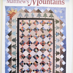 May include: A quilt pattern called "Matthew's Mountains" with a colorful patchwork design. The quilt is surrounded by a border of black and white triangles, and the center features a large square of smaller squares in various colors and patterns. The quilt is set against a blue sky with white stars and a sun.