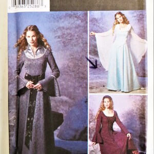May include: Simplicity Costumes sewing pattern number 9891 for sizes 6, 8, 10, and 12. The pattern includes three different costume designs: a long, flowing gown with a high neckline and long sleeves, a shorter gown with a fitted bodice and bell sleeves, and a long gown with a fitted bodice and long sleeves. The pattern is printed on a white background with black text and illustrations.
