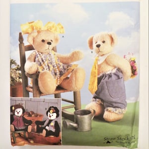 May include: A Simplicity Crafts sewing pattern for making teddy bears. The pattern includes instructions for making four different bears, including a girl bear in a yellow dress, a boy bear in a blue shirt and pants, and two smaller bears in different outfits. The pattern also includes instructions for making a small watering can.