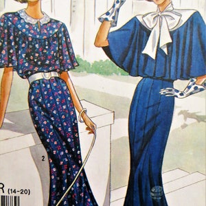 May include: Two women wearing vintage dresses. The woman on the left is wearing a blue and white floral dress with a white collar and a white belt. The woman on the right is wearing a solid blue dress with a white collar and a white bow. Both women are wearing white gloves and hats.